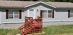 a white house with brown shutters and red steps