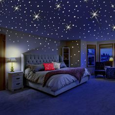 a bedroom with stars on the ceiling and blue carpeted flooring is lit up by two lamps