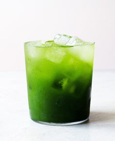 a green drink with ice on the rim