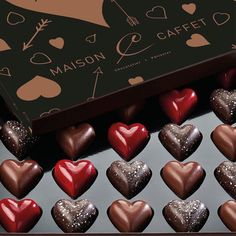 heart shaped chocolates are in a box on the table next to it is a sign that says maisonon cafe