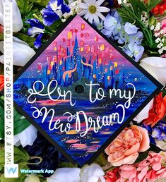 a graduation cap with the words, i'm to my new dream on it surrounded by flowers