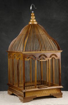 a wooden bird cage sitting on top of a table