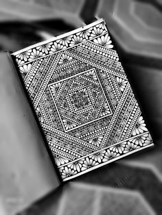 a black and white photo of a playing card with intricate designs on the front cover