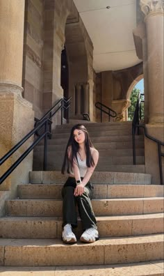 a young woman sitting on the steps of a building