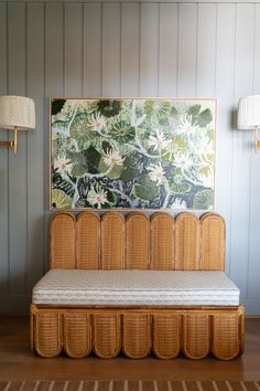 a wicker daybed in front of a painting on the wall