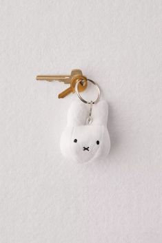 a keychain with a small white animal on it's side hanging from a hook