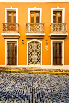 an orange building with two balconies on the second floor