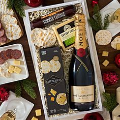 an assortment of cheeses, crackers and wine in a gift box on a table