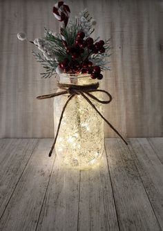 a mason jar filled with christmas lights and greenery