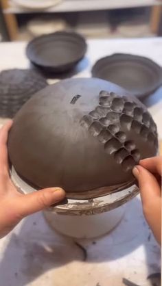 a person is working on a clay vase