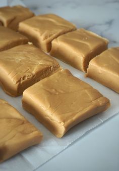 several pieces of peanut butter on a white tablecloth and some are cut into squares