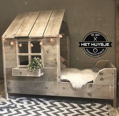 a bed made out of pallet wood with a little house on top