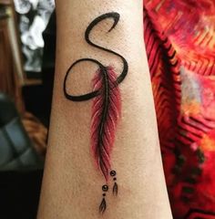 a woman's arm with a tattoo on it that has an arrow and a feather