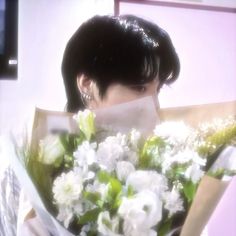 a woman holding a bouquet of white flowers