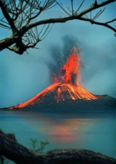 an active volcano spewing lava into the ocean with trees in front of it