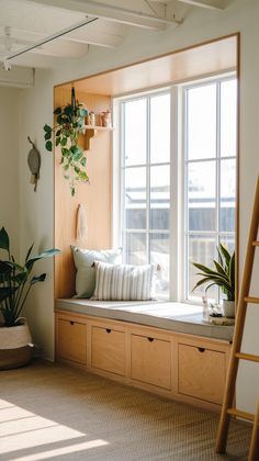 a window seat with pillows and plants in it