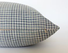 a blue and white checkered pillow sitting on top of a table