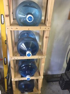 several large blue water bottles are stacked on wooden shelves