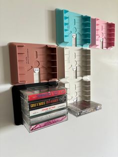 there are several cassettes and cds on the wall next to each other, all in different colors