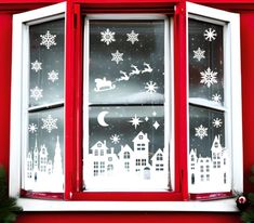 a red window decorated with snowflakes and santa's sleighs