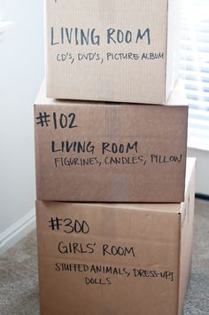 three boxes stacked on top of each other in the middle of a living room floor