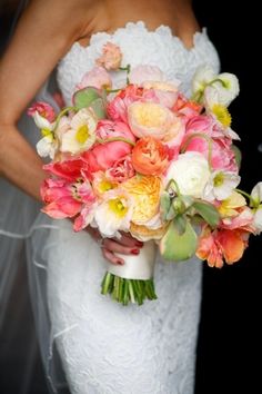 a bride holding a bouquet of pink and yellow flowers on her wedding day in front of a black background