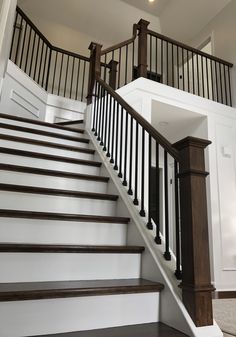 a staircase with wooden handrails and white walls