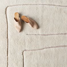 two pairs of shoes sitting on top of a rug