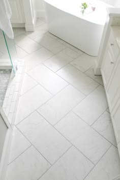 a white bathroom with a tub and sink