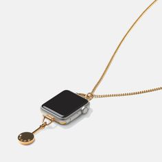 an apple watch is attached to a gold chain with a black cell phone on it