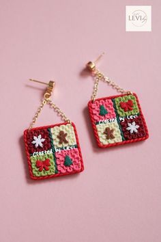 two square shaped earrings with flowers and words written on them, hanging from gold earwires