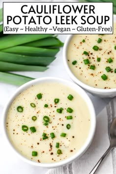 two bowls of cauliflower potato leek soup with green onions on the side