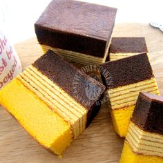 several slices of cake sitting on top of a wooden cutting board next to a cup