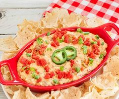 a red casserole dish filled with salsa and chips