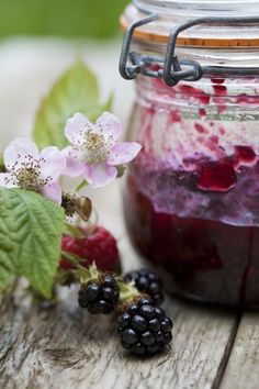 berries and blackberry jam in a jar on a wooden table