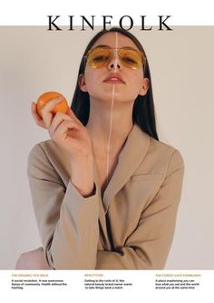 a woman wearing sunglasses holding an orange in front of her face with the words kinfolk above her head