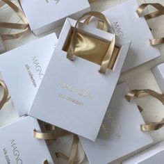 several white boxes with gold ribbons on them