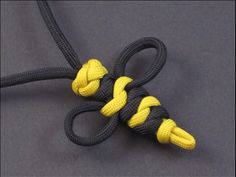 two yellow and black ropes are connected to each other on a gray surface with grey background