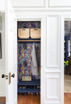 an open closet with shoes and coats on the shelves, next to a coat rack