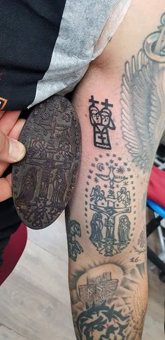 a person with tattoos on their legs holding an object