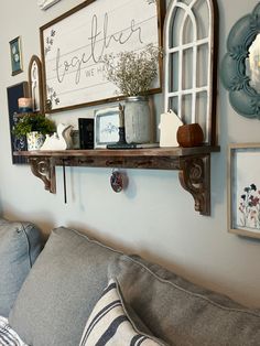 a living room filled with furniture and decor on top of a wooden shelf next to a window