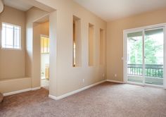 an empty living room with sliding glass doors