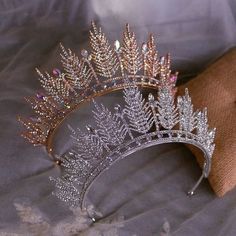 a tiara with crystal leaves on it is sitting on a cloth covered tablecloth