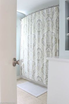 a bathroom with a shower curtain and rug on the floor in front of the door