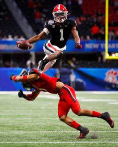 two football players are running for the ball in front of each other on a field