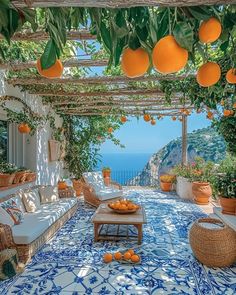 an outdoor patio with oranges hanging from the ceiling and wicker furniture on the floor