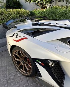 a white sports car parked in front of a house