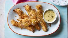 fried chicken sticks on a plate with dipping sauce