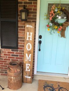 a wooden welcome sign next to a bicycle on the front porch with an old pail