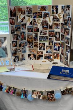 a table topped with pictures and photos next to a wall covered in paper garlands